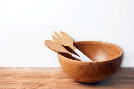 Wooden bowl and cutlery on white background and table. Natural serving table settingの写真素材