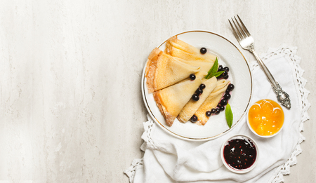 Homemade pancakes with honey, jam and berries with powder sugar.の写真素材