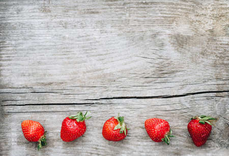 Old wooden background with strawberry. Flat lay, top viewの写真素材