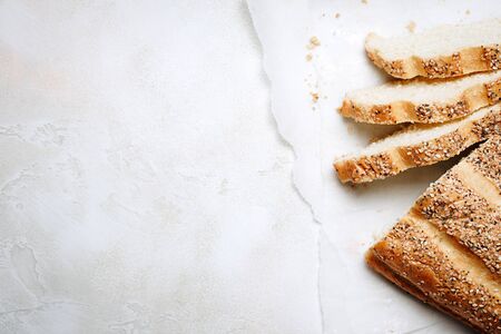 Sliced sesame bread on white concrete background. Top view, flat lay.の写真素材