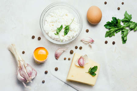 Food organic ingredients: cottage cheese, egg, garlic and parsley on white rustic concrete background. Top view, flat lay.の写真素材