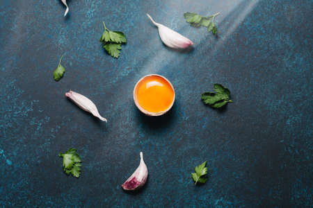 Food organic ingredients: egg, garlic and parsley on dark background. Place for text. Top view, flat layの写真素材