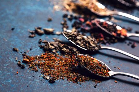Spoons full of different tea on dark vintage background. Top view, flat lay. Place for your textの写真素材