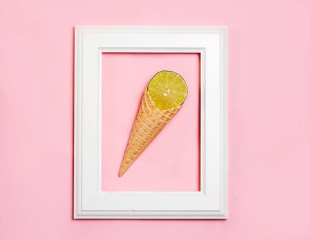 Lime ice-cream in white wooden frame on pink background. top view, flat layの写真素材