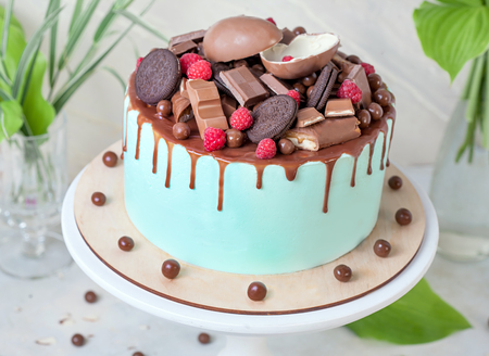Chocolate cake with sweet raspberries and candies with Mint glaze on white wooden stand. close upの写真素材
