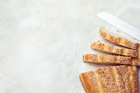 Sliced sesame bread on white concrete background. Top view, flat lay