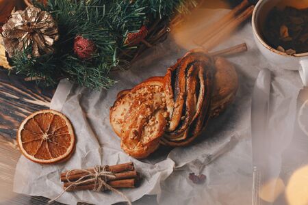 Tasty homemade bun with nuts and cinnamon on holiday christmas table, close up.