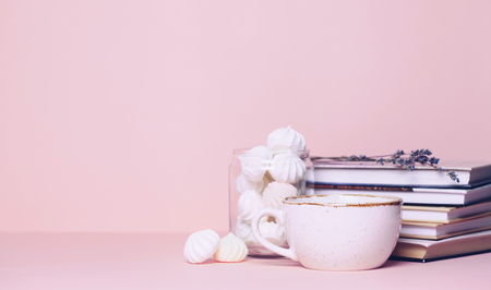 Close up of two cups and a book on pink background. Copy space for your text or designの写真素材