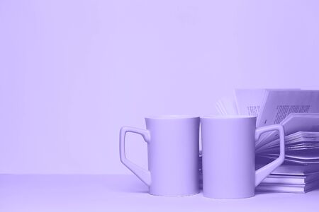 Close up of two cups and a book , ultra violet color style. Copy space for your text or design.の写真素材