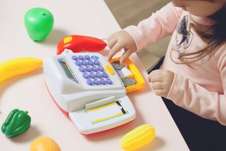 Little pretty girl playing with toy store. education process.の写真素材