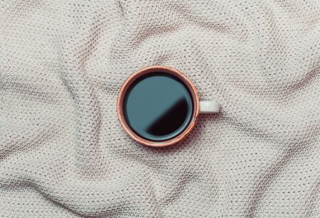 Coffee cup on wool background. Flat lay, top view. sweater knitted texture.の写真素材