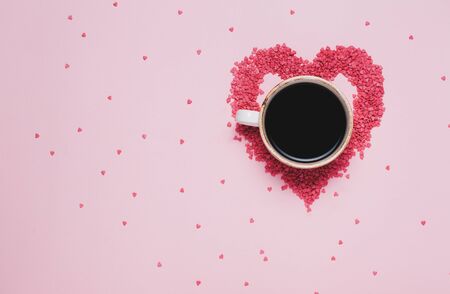 Cup of black coffee and pink hearts on pink background. St valentines day concept, womans day. top view, flat layの写真素材