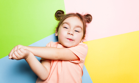 Pretty 4-year little girl with funny face on multicolor background. Bright colors and stylish pictureの写真素材