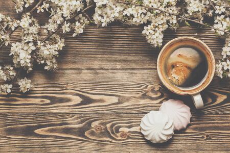 Spring top view wooden background with coffee and blossoming tree branches on wooden background. Place for text. Copyspace.の写真素材
