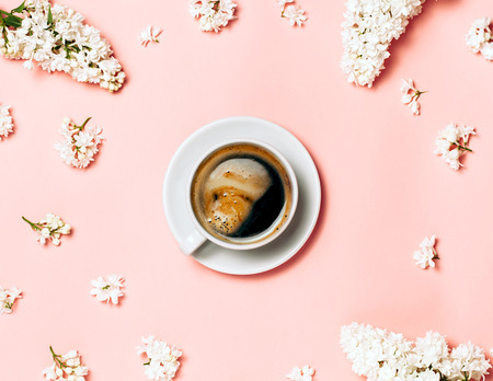 Flat lay of cup of coffee in frame made from lilac flowers. Beautiful spring picture, perfect foam on coffee, pure conceptの写真素材