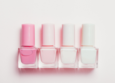 Colorful nail polishes bottles isolated on white. Cut out. Trendy manicure minimalistic conceptの写真素材