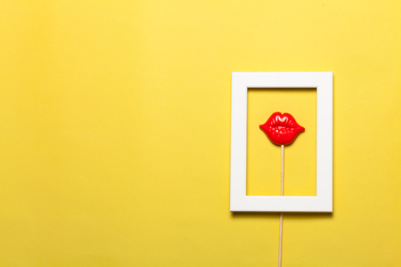 Frame with red lips inside on yellow background.の写真素材
