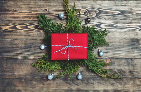 Christmas gift box with fir branches ans decorations on rustic wooden background. Top view, flat lay.の写真素材