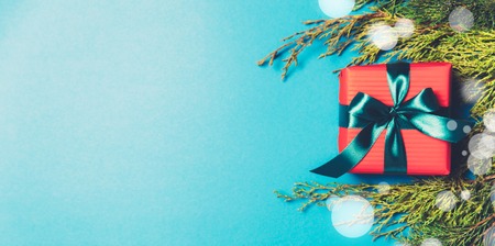 Christmas gift boxes wrapped in red paper on blue frozen background. Bright and festive Christmas...