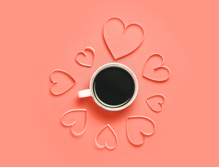 Cup of coffee and paper hearts on Living Coral background. Valentines day greeting concept.の写真素材