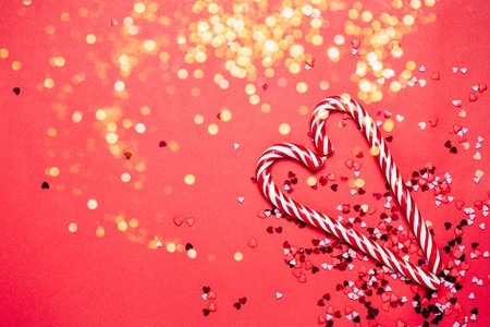 Red holiday background with heart shaped candy and little hearts on background.の写真素材