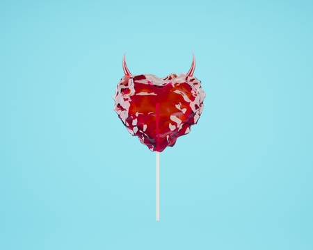 Valentine's day minimal concept: red heart-shaped lollypop hardcandy with horns on blue background.の写真素材