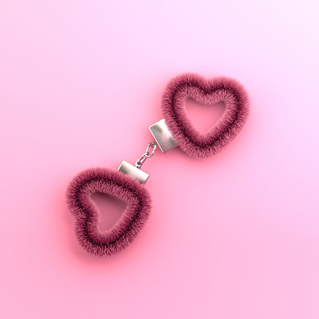 Heart shaped pink fur handcuffs on pink background. Valentine's day creative minimal concept. Top view, flat lay.の写真素材