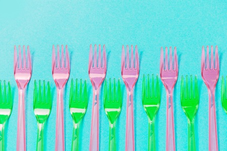Plastic forks pattern on blue background. Top view, flat lay. Environment pollution concept.の写真素材