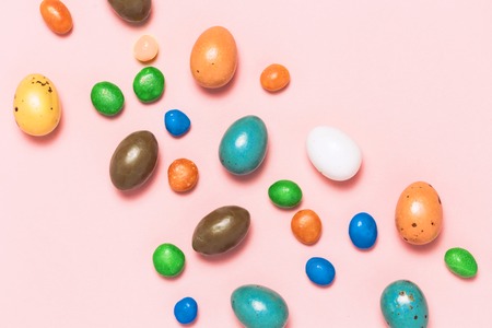 Easter frame made from colorful eggs and big chocolate egg flat lay on white background. Top view, copyspace for text.の写真素材
