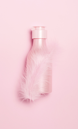 Creative minimal beauty and health background with pink cosmetic bottle. Minimal top view and flat lay of cosmetic on pink and blue trendy background.の写真素材