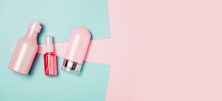 Creative minimal beauty and health background with pink bottle. Minimal top view and flat lay of cosmetic on pink and blue trendy background.の写真素材