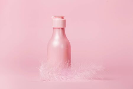 Creative minimal beauty and health background with pink cosmetic bottle. Minimal top view and flat lay of cosmetic on pink and blue trendy background.の写真素材