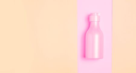 Creative minimal beauty and health background with pink bottle. Minimal top view and flat lay of cosmetic on pink and blue trendy background.の写真素材