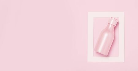 Creative minimal beauty and health background with pink bottle. Minimal top view and flat lay of cosmetic on pink and blue trendy background.の写真素材