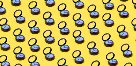 Top view of Three Eye shadows pallets and applicators on yellow background. Fashion cosmetic set....
