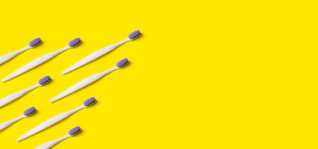 Toothbrush minimal pattern on yellow background. Trendy stylish health care concept.の写真素材