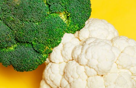 Broccoli and cauliflower on yellow background. minimal vegetarian concept.の写真素材