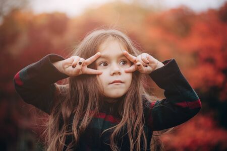 Portrait of cute little girl in autumn forest.の写真素材