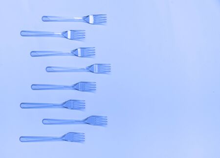 Plastic fork pattern on classic blue background. Concept of color 2020.