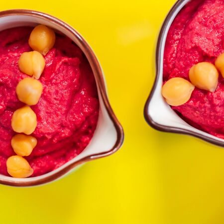 Pink Hummus with beet on yellow bright plate. Vegan healthy eating. op view, flat lay.の写真素材