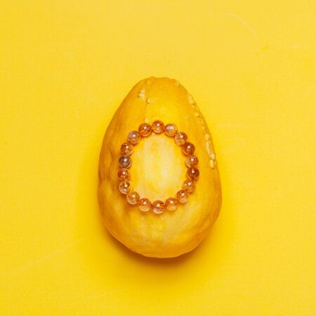 Amber semiprecious bracelet on yellow background. Top view, flat lay. Creative minimalist photo.