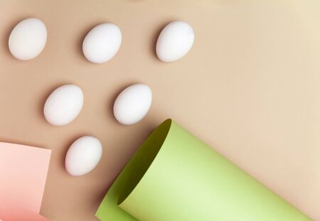 Creative Easter beige and pink background with white eggs. Easter holiday minimal concept.