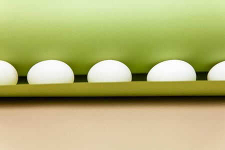 Creative Easter beige and pink background with white eggs. Easter holiday minimal concept.の写真素材