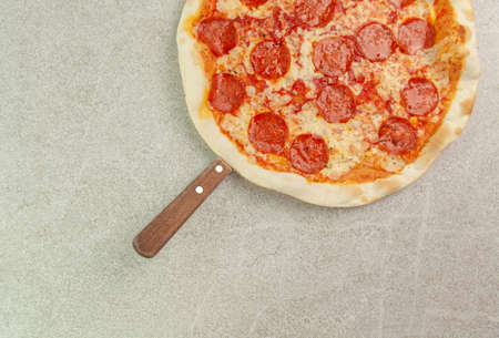 Pepperoni pizza on grey background table. Traditional italian cuisine.