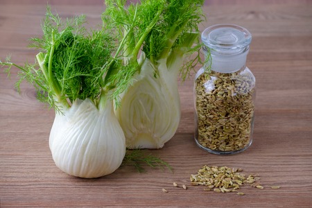 fennel bulb and seeds in a glass jar on wooden backgroundの写真素材