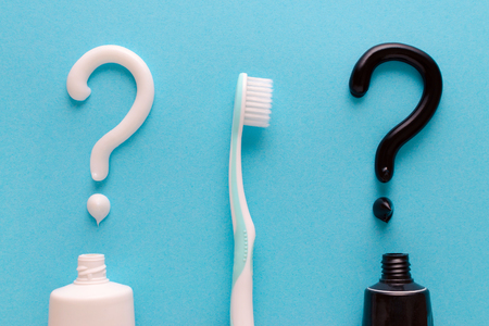 question from white and black toothpaste, teeth care concept, toothbrush on blue backgroundの写真素材
