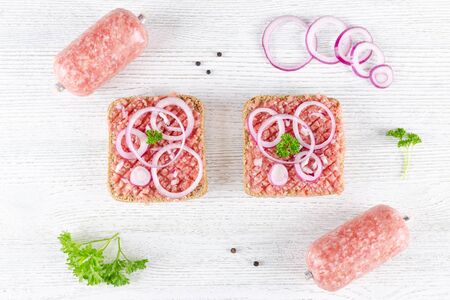 german food mett ground pork, bun and raw meat with onion, pepper and parsley, ingredientsの写真素材
