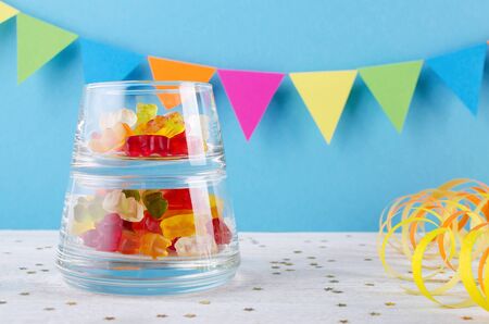 jelly candy in a glass bowl on blue party backgroundの写真素材