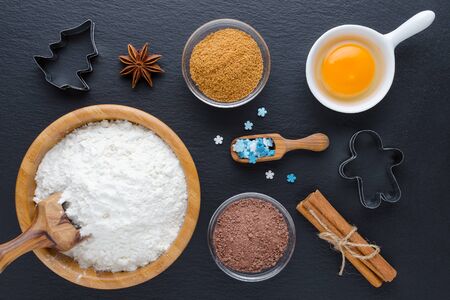 ingredients and kitchen tools for dessert baking on black background