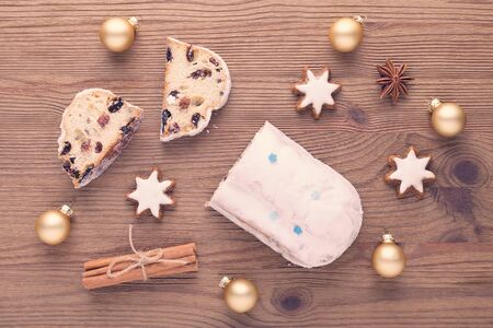 traditional german christmas cake stollen with cookies and decoration on wooden tableの写真素材